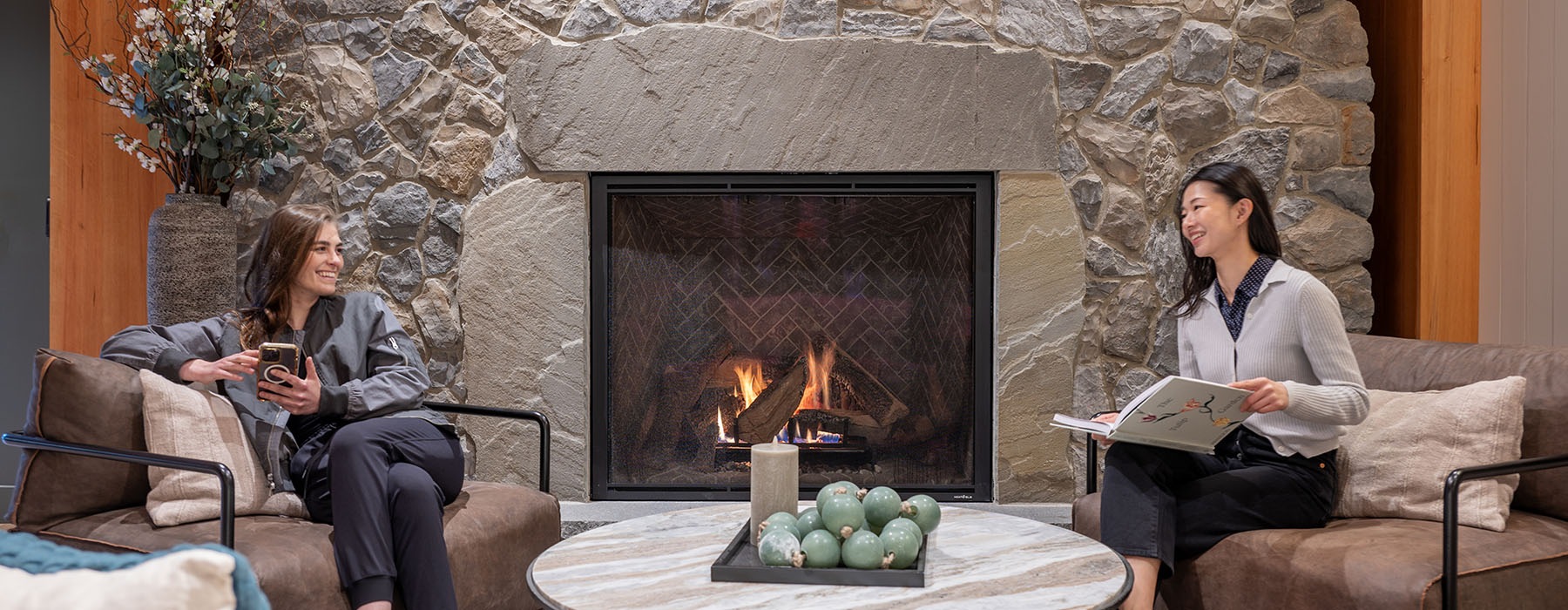 contact banner showing two women by a fireplace at the lodge apartments in marlboro ma