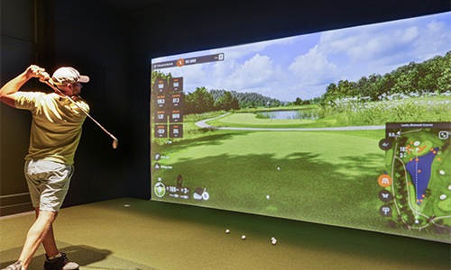 a man playing a golf simulator